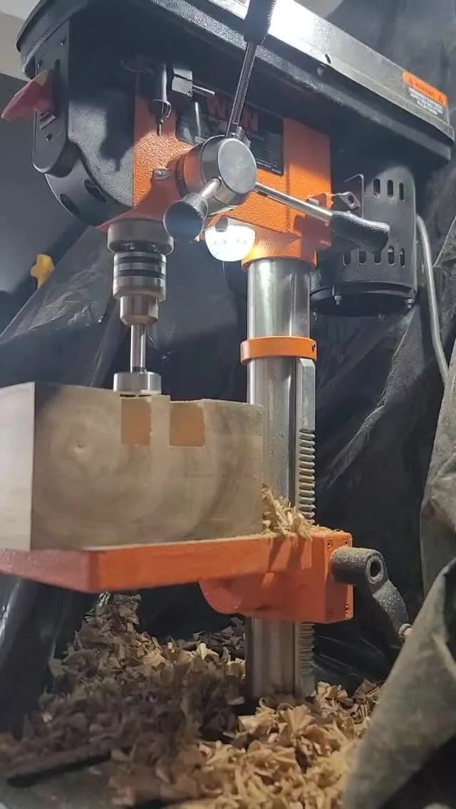 Heritage American Woodworks: a drill press cutting into a hardwood blank, shavings on the bench