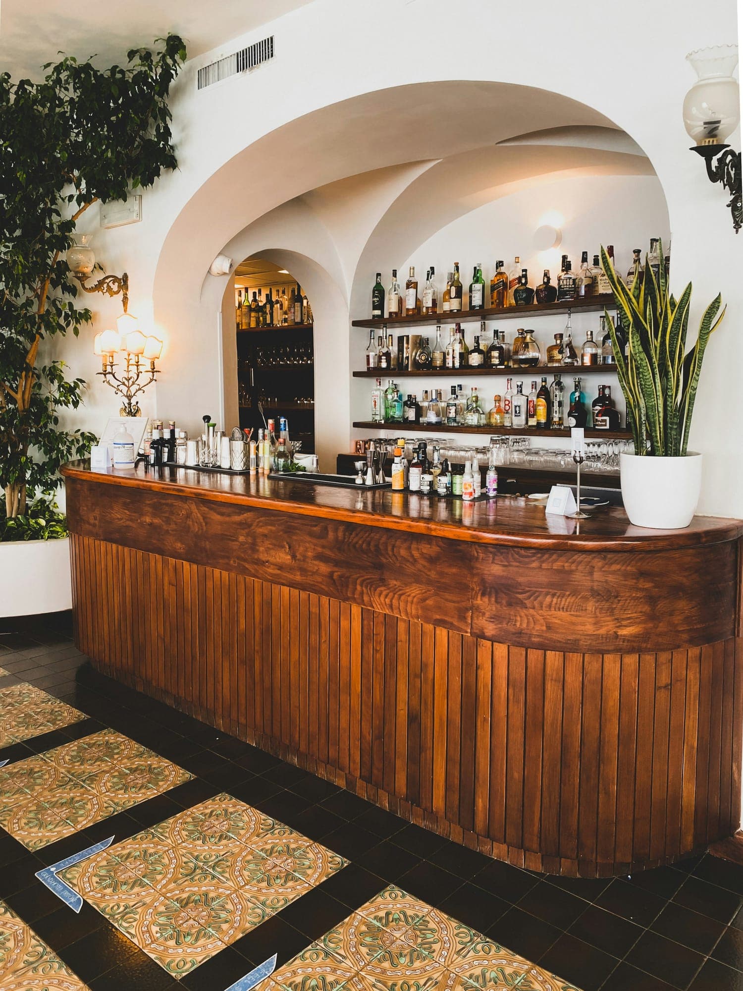 A hardwood bar counter under whitewashed arches