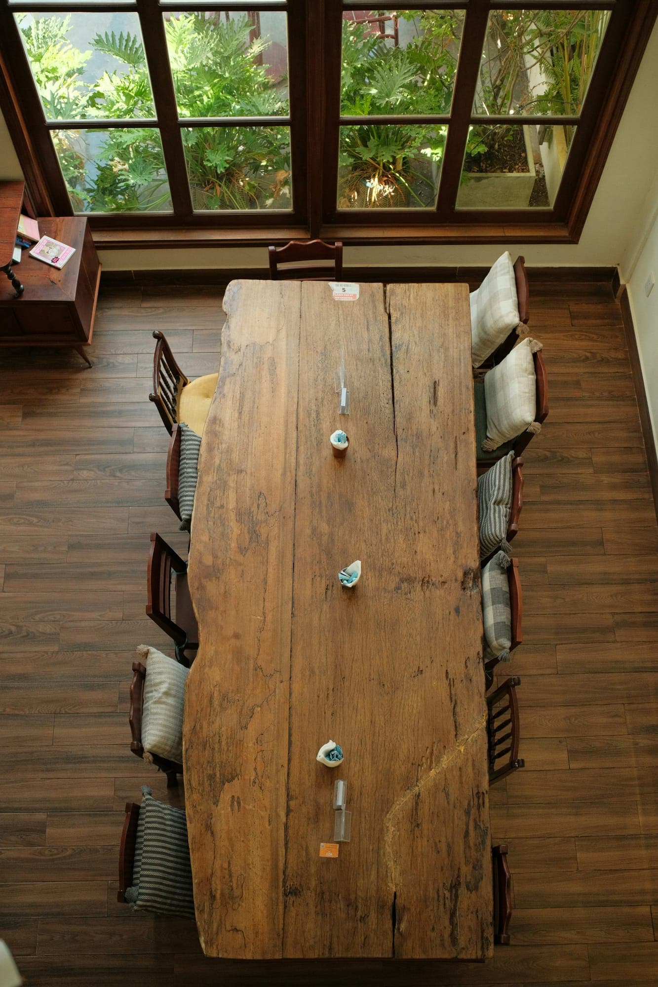 A long reclaimed plank table set for ten, seen from above