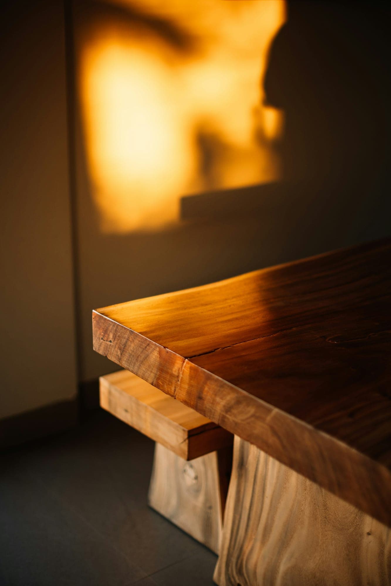 A thick hardwood slab table top in low golden light