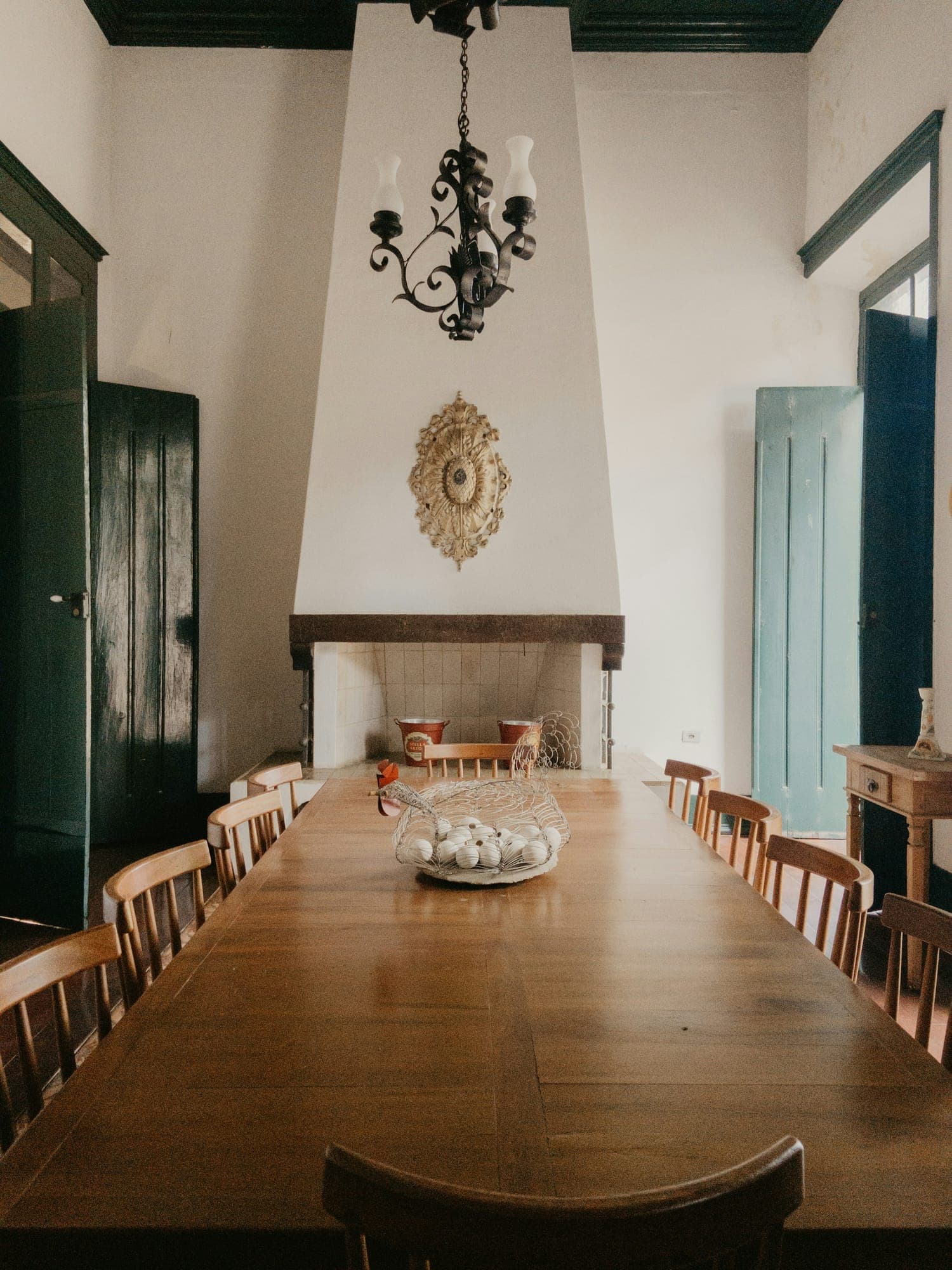 A twelve-seat oak table in front of a fireplace